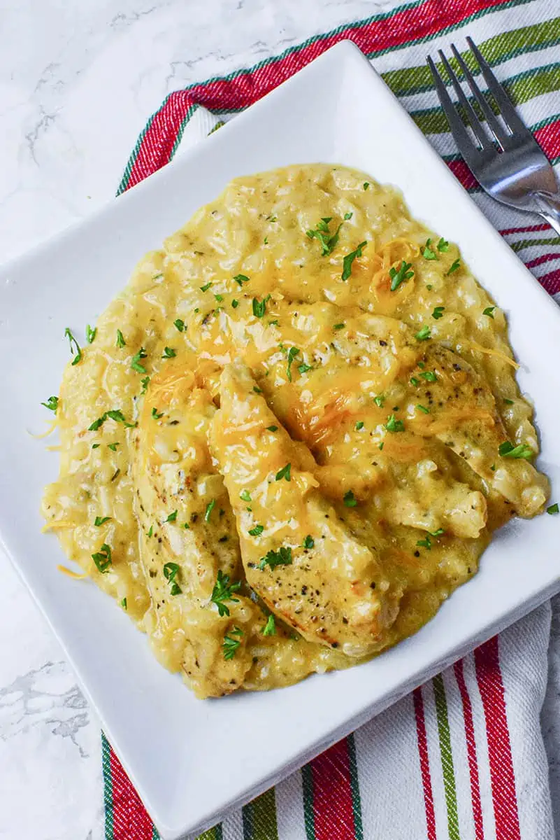 Chicken with saucy rice on a dinner plate.