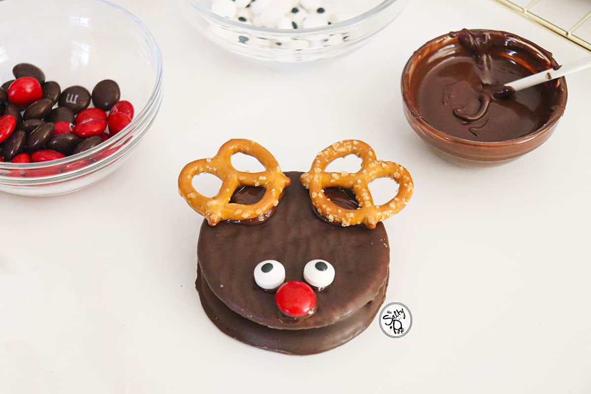 The pretzel antlers are added at the top of the cookie. 