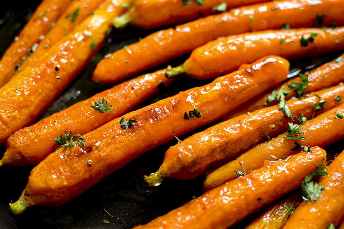 Freshly roasted hot honey carrots in a skillet.