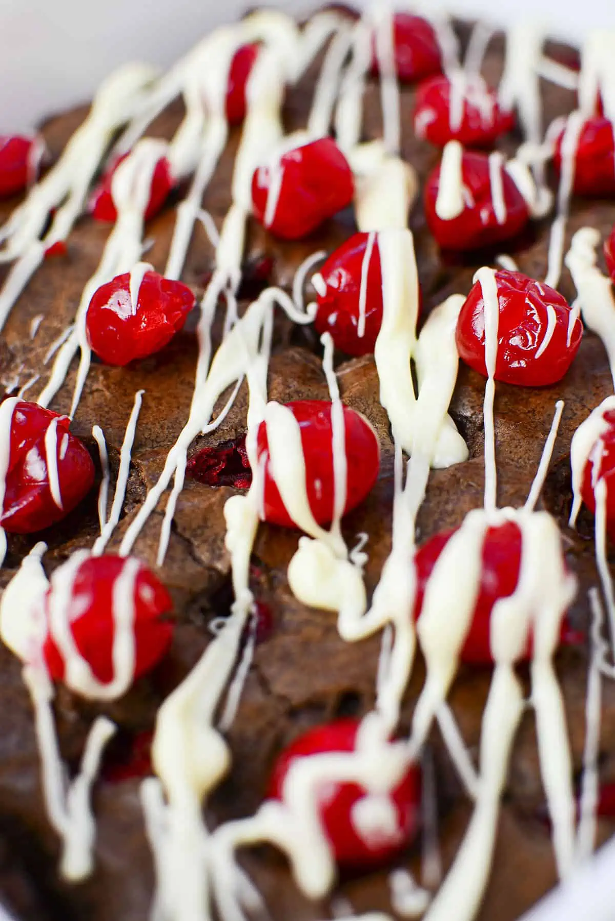 A closeup image of the brownies covered in white choccolate drizzle