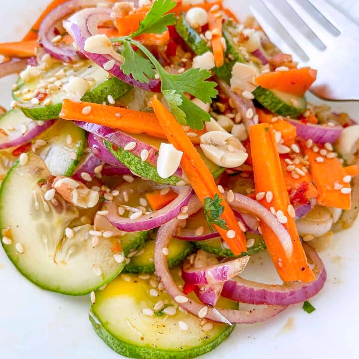 The asian carrot cucumber salad on a white plate.