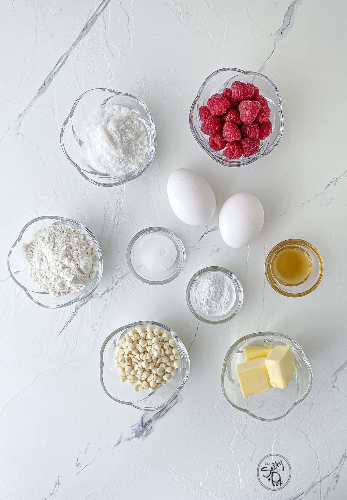 A photo of the ingredients needed for the recipe. Flour, eggs, butter, salt, baking powder, raspberries, vanilla, etc.