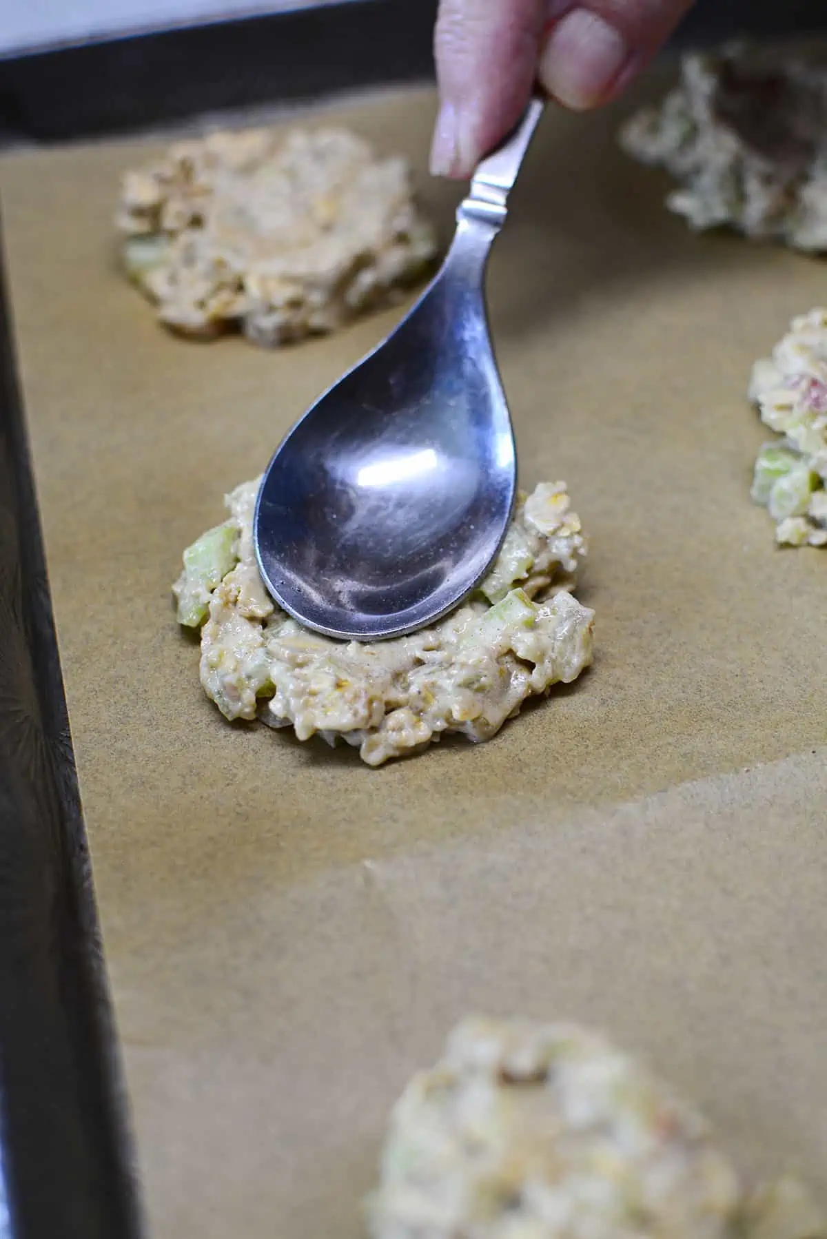 Pressing down the cookies with a spoon to flatten then slightly. 