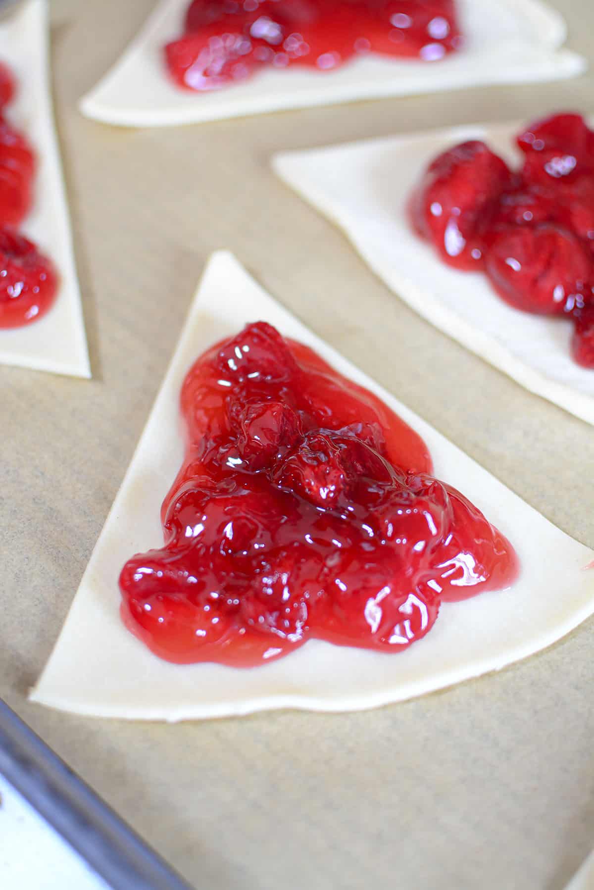 Strawberry rhubarb pie filling placed on a triangle of pie pastry.