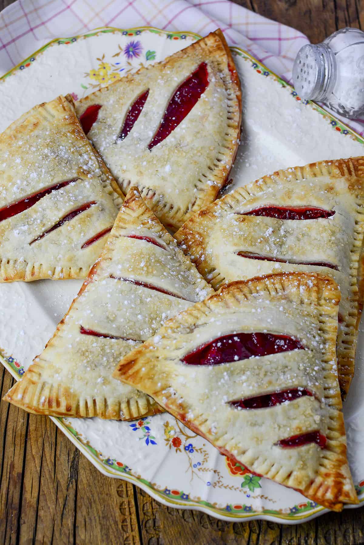 5 Strawberry Rhubarb Hand Pies on a decorative plate.