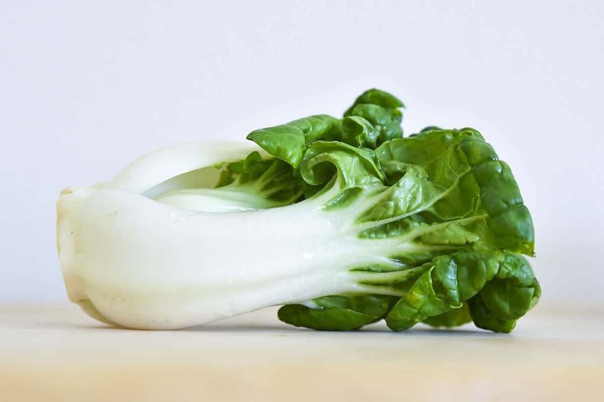 Bok Choy on a creamy color cutting board.