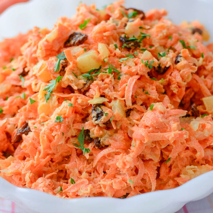 Shredded carrot pineapple salad in a white bowl.