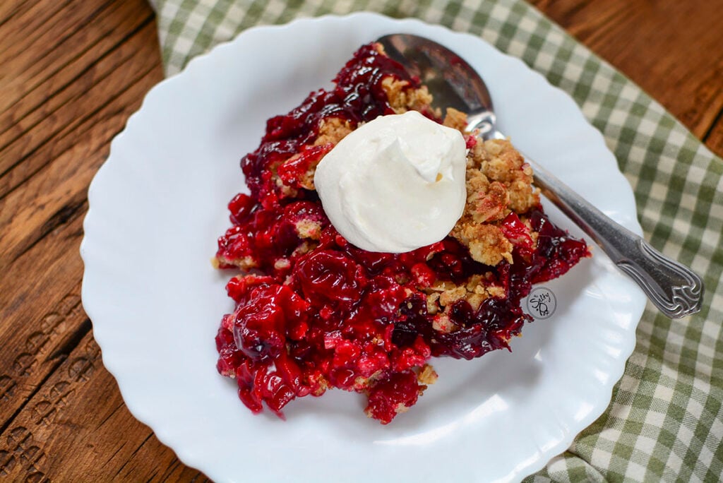 Fruit crisp on a white plate with green checked napkin underneath.