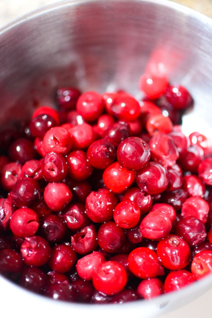 Pitted cherries in a silver bowl.