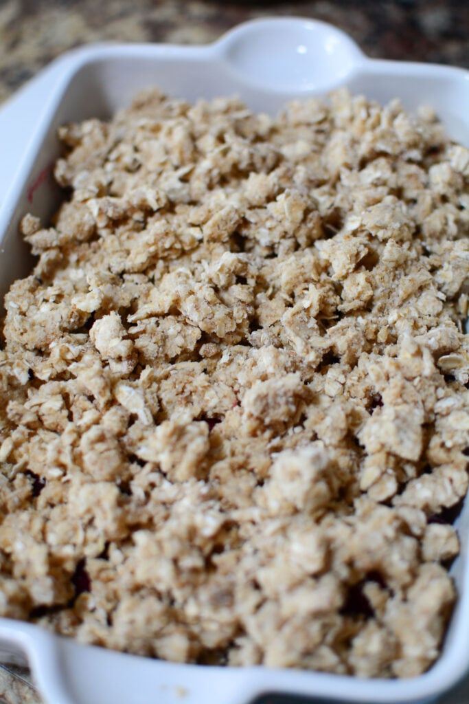 The topping is placed on the fruit in the pan.