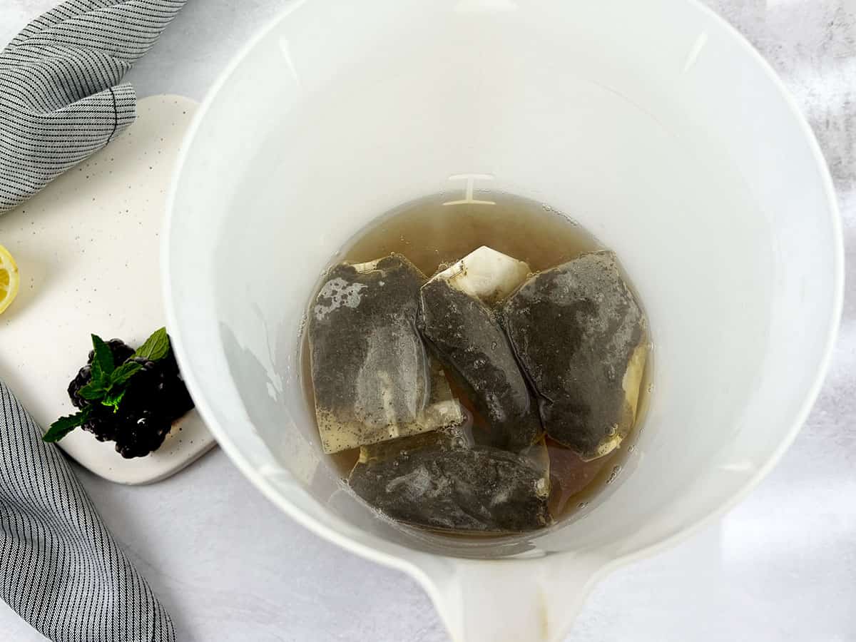 Black tea bags in hot water to make tea.