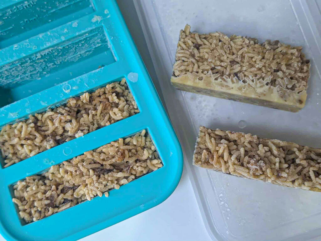 Stick of butter rice frozen and two portions placed outside of the souper cube silicone forms.