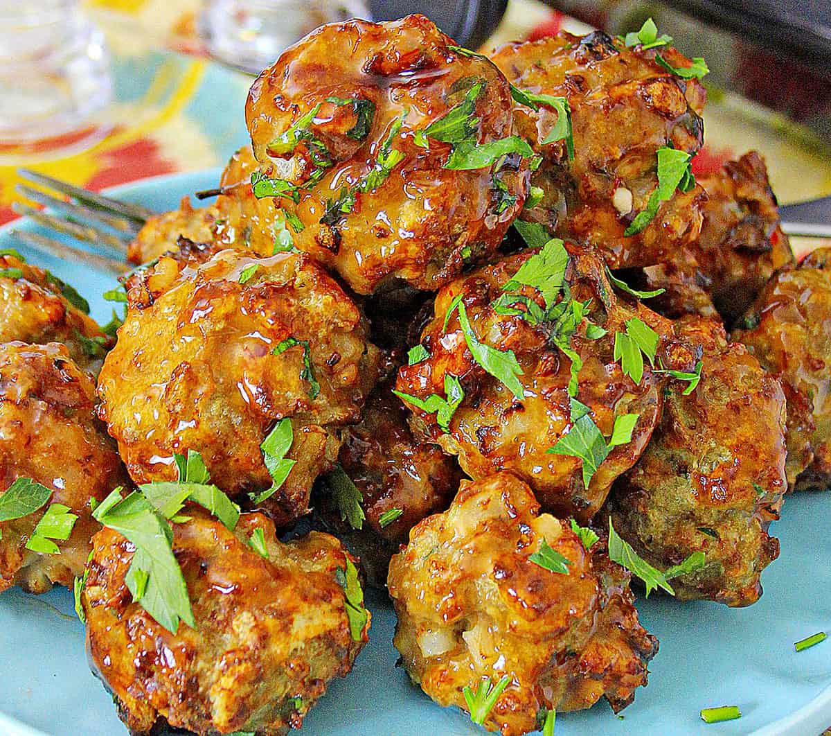 Air fryer meatballs piled on a blue plate.