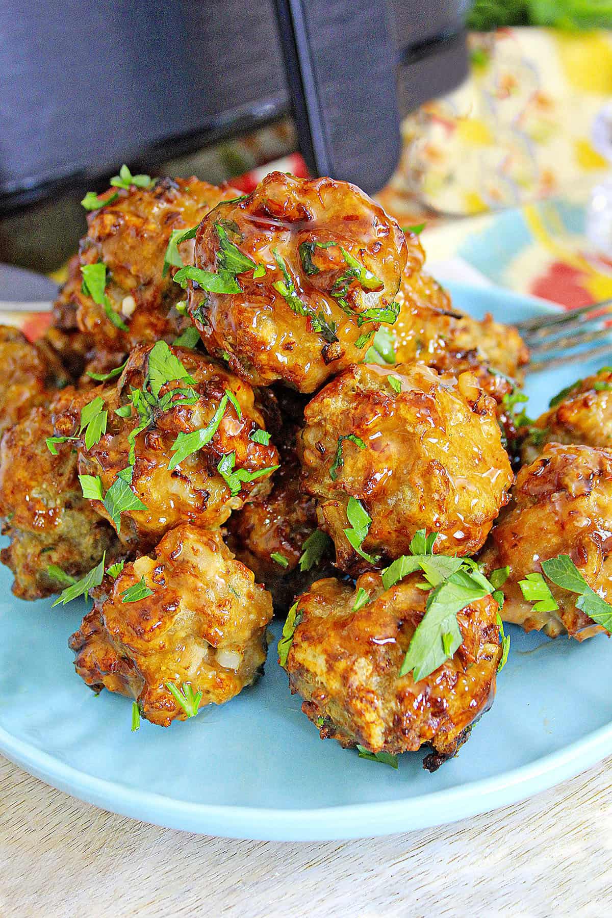 Air fryer meatballs with fresh parsley garnished.