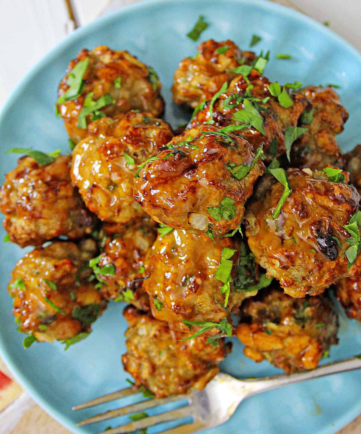 Cooked meatballs with parsley garnished on top. 