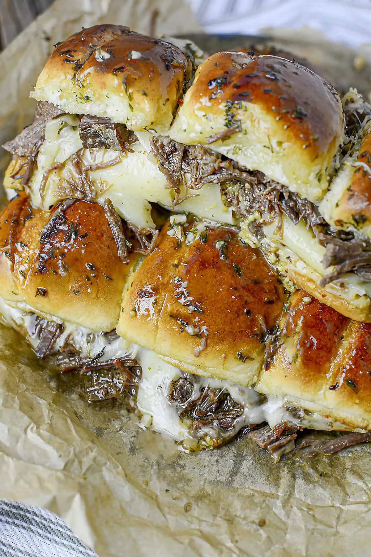 Beef Brisket Sliders fresh out of the oven on parchment paper.