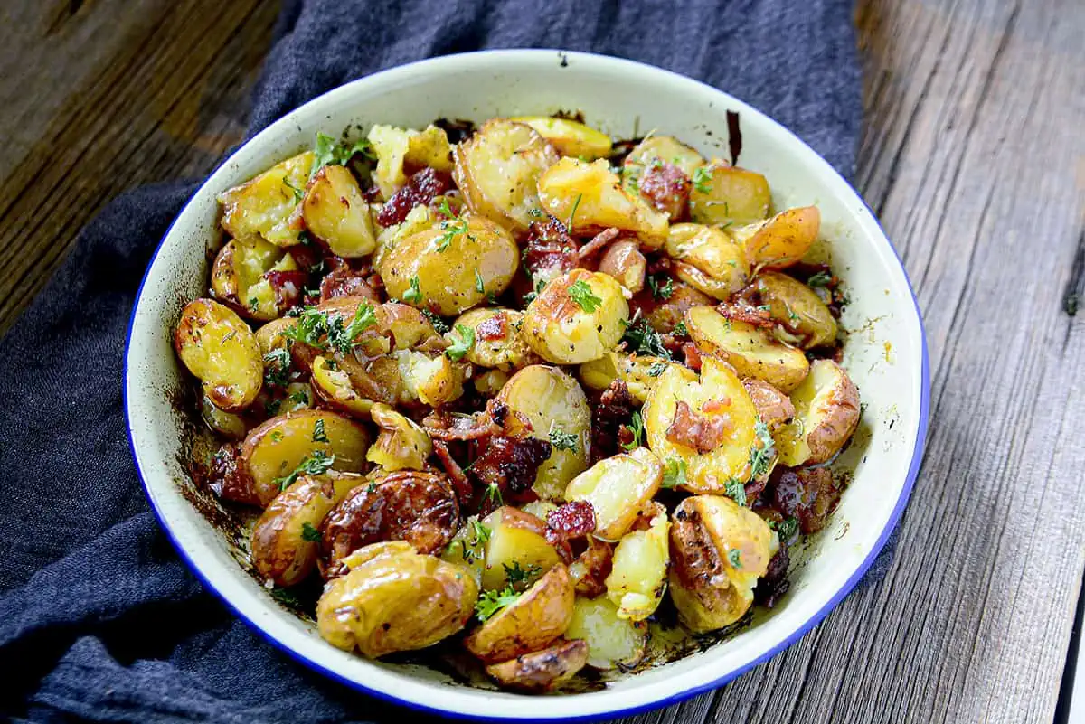 Crispy, buttery, smoky, salty, herb-y potatoes in an enamel baking dish.