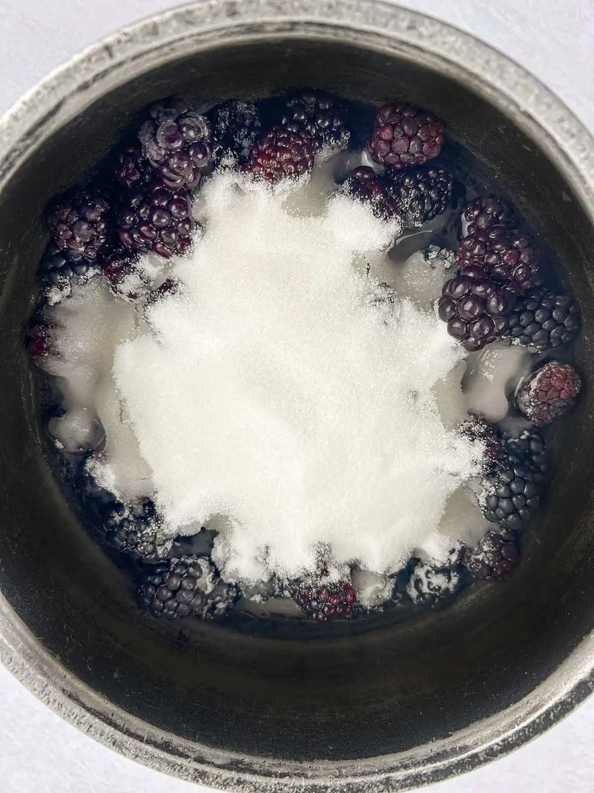 Blackberries, sugar and water in a pot, ready to be boiled.