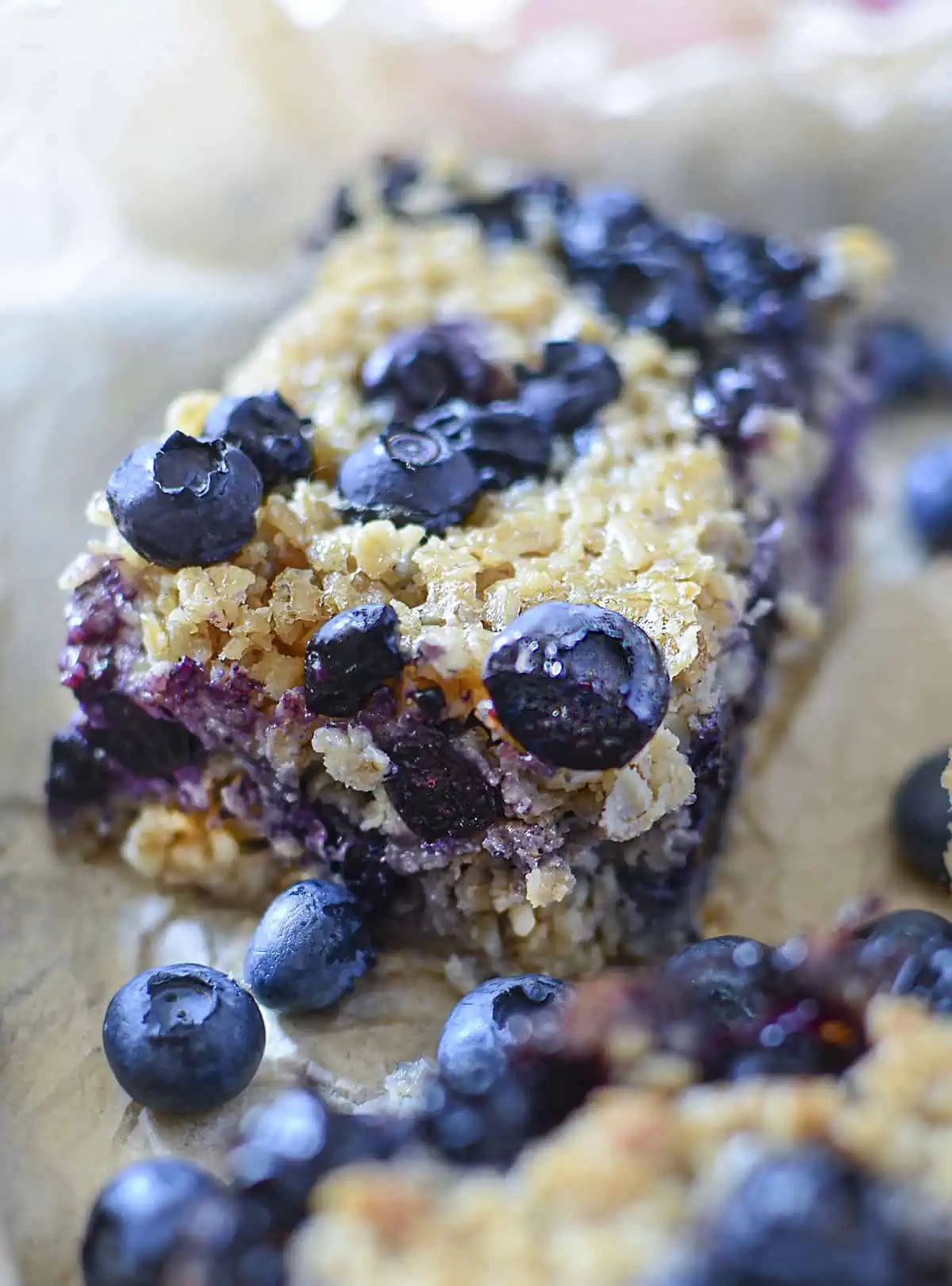 A blueberry oatmeal bar on brown parchment paper
