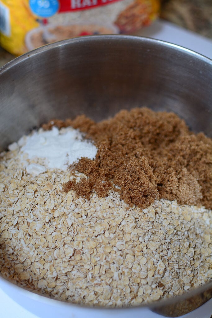 A bowl with dry ingredients like oats, brown sugar and baking powder.