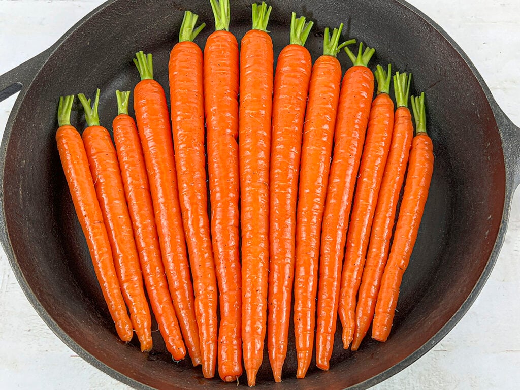 Raw carrots in a cast iron pan.