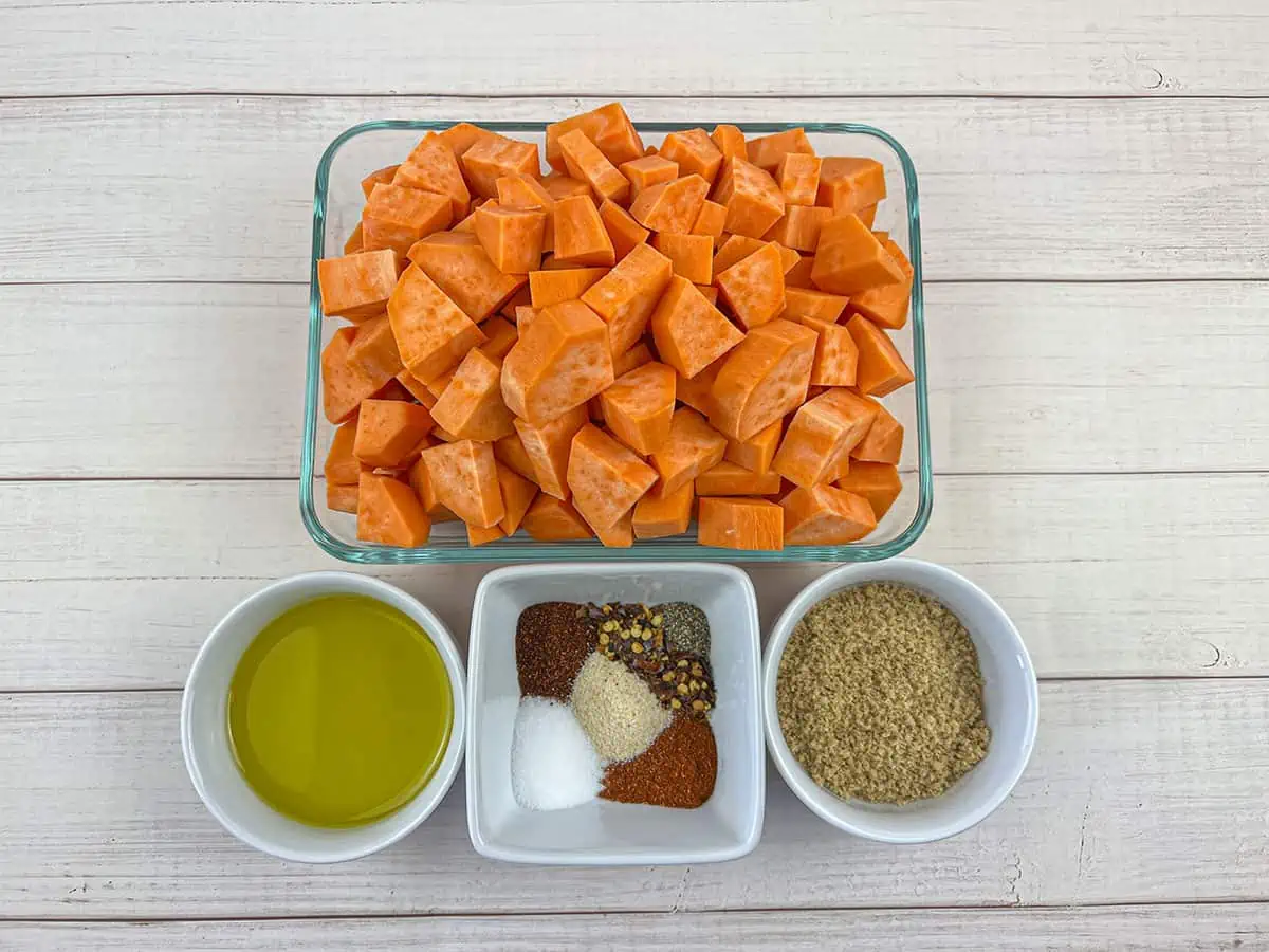 Ingredients for the spicy sweet ptoatoes recipe. Sweet potatoes at the top, then below is avocado oil, spices and brown sugar.