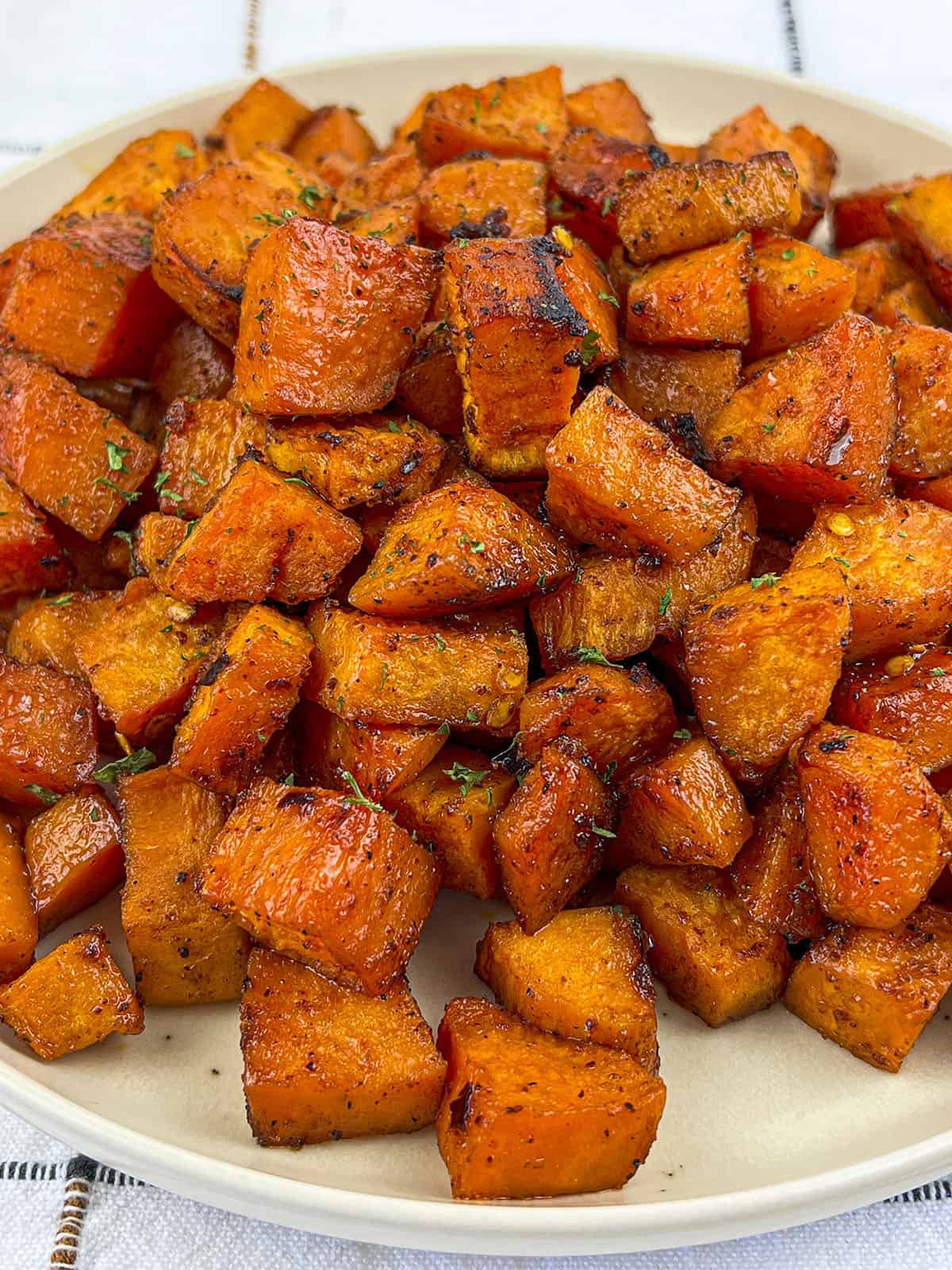 A pile of spicy sweet potatoes on a grey plate.