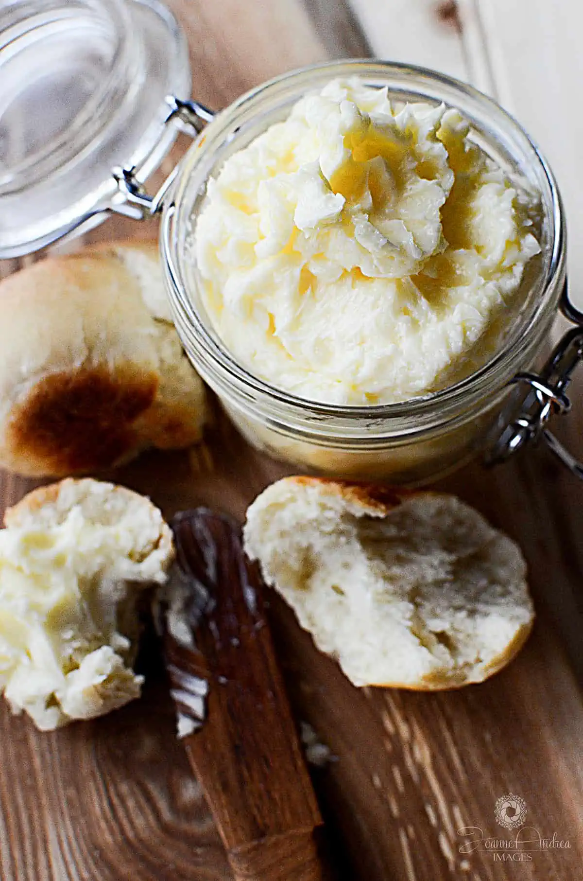 A jar full of homemade butter on a wooden cutting board.