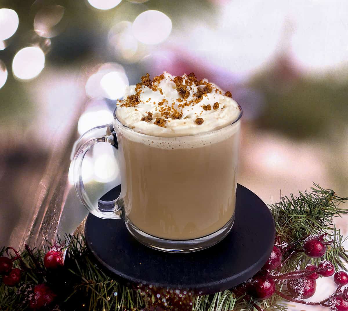 Spiced Rum Hot Chocolate in a glass mug with whipped topping and ginger cookie crumbles on top.