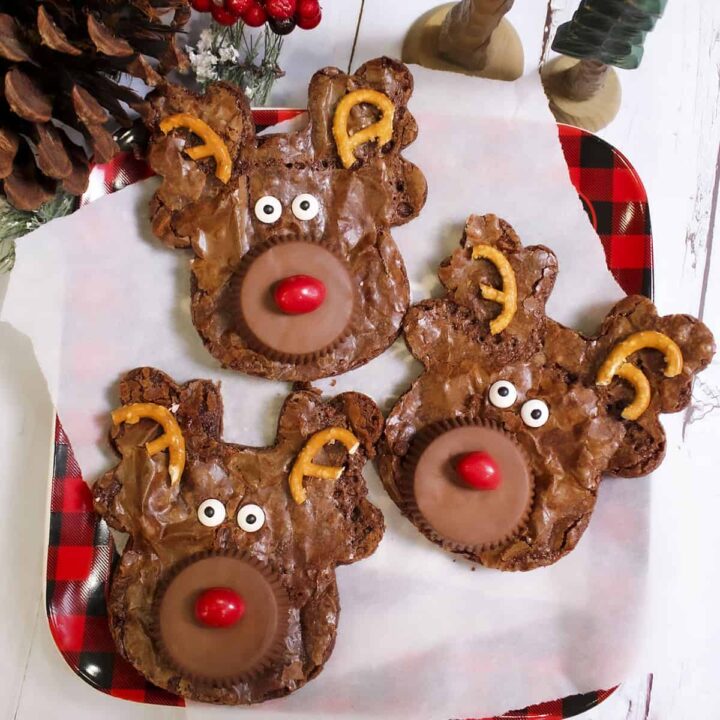 3 reindeer brownies on a plate lined with parchment paper.