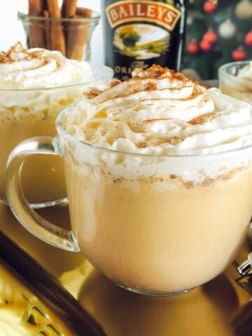 Eggnog and Baileys in a mug with whipped cream on top.