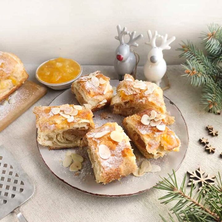 Banket pastry on a plate with christmas decor surrounding it.