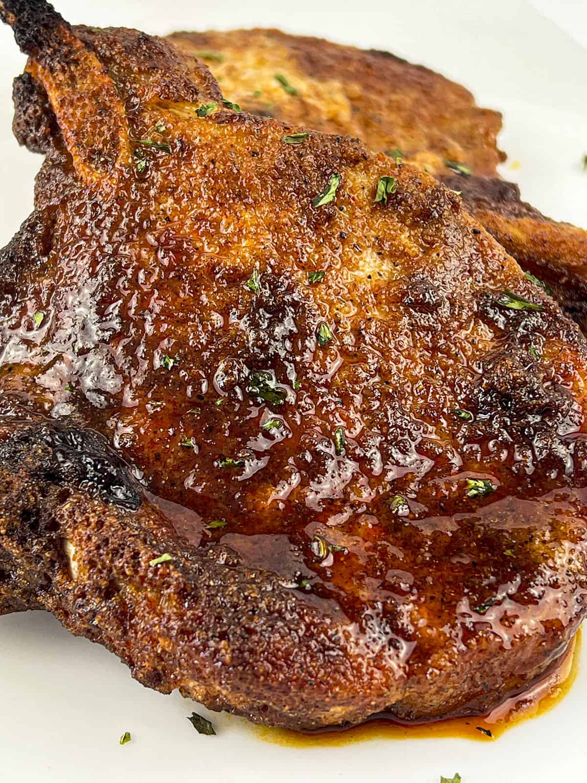 A close up photo of two air fryer pork chops.