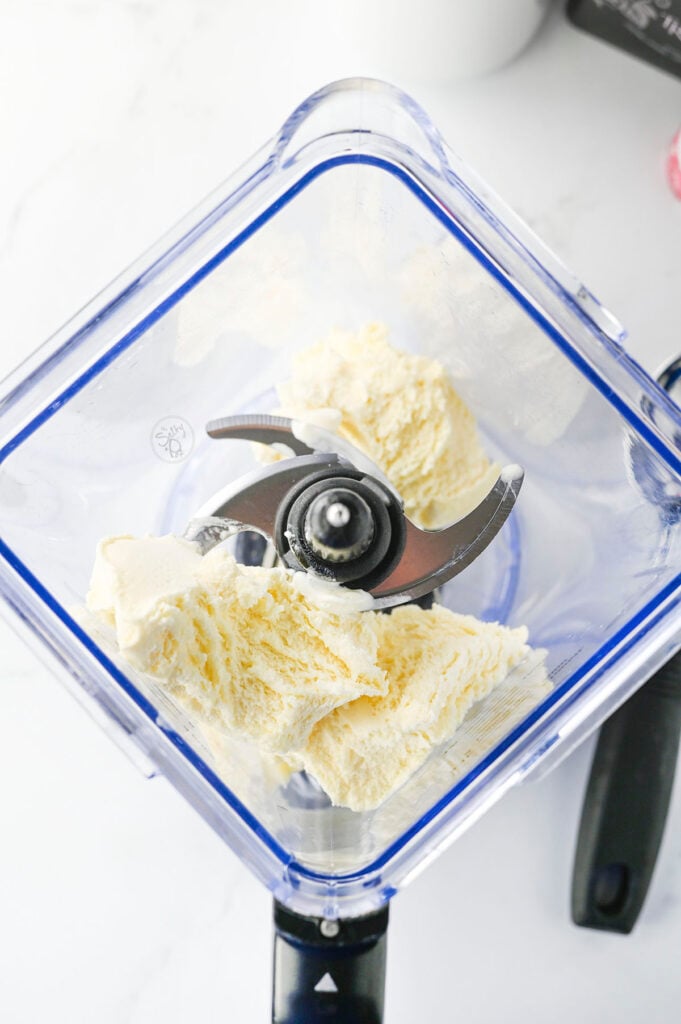 Adding vanilla ice cream to the blender. 