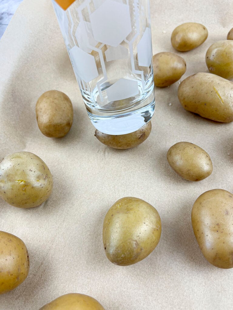 The cooked potatoes are smashed down with the bottom of a heavy glass.