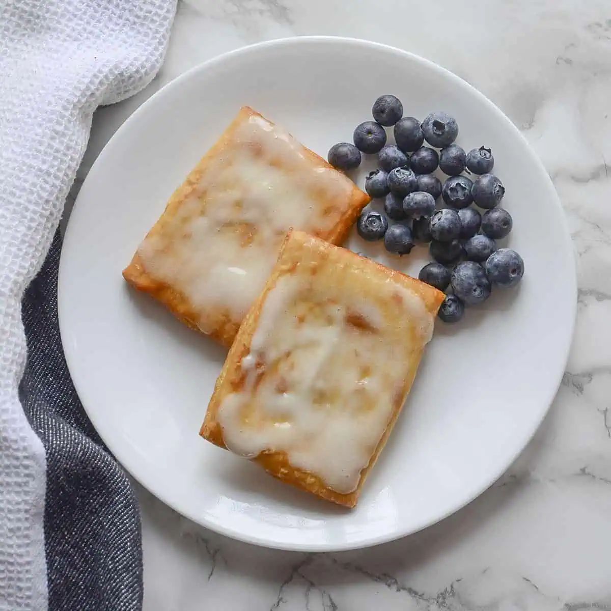 Air Fryer Toaster Strudels with blueberries on the top right, square image.