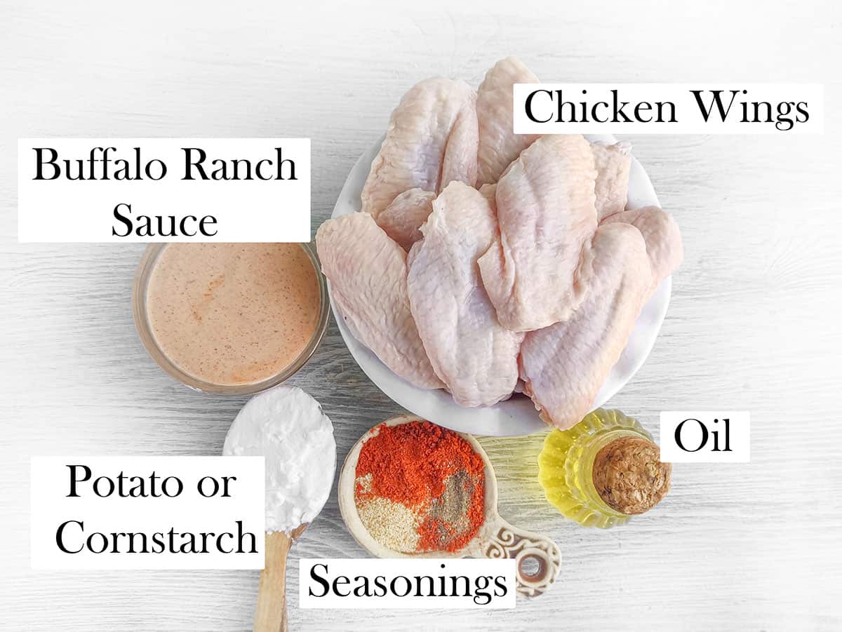 Ingredients for the baked wings. Chicken wings, Oil, seasonings, potato or cornstarch, and buffalo ranch sauce.