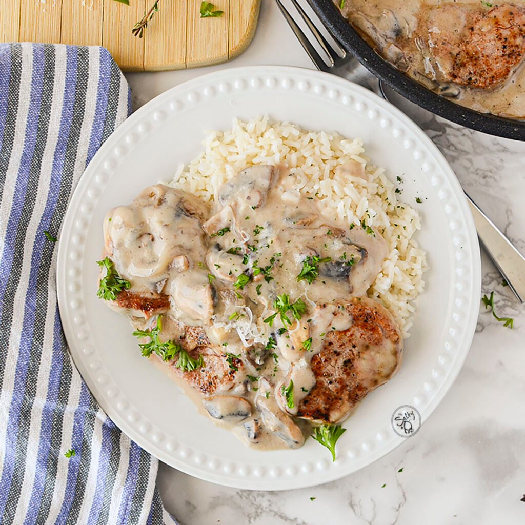 Plated pork medallions in a creamy mushroom sauce.