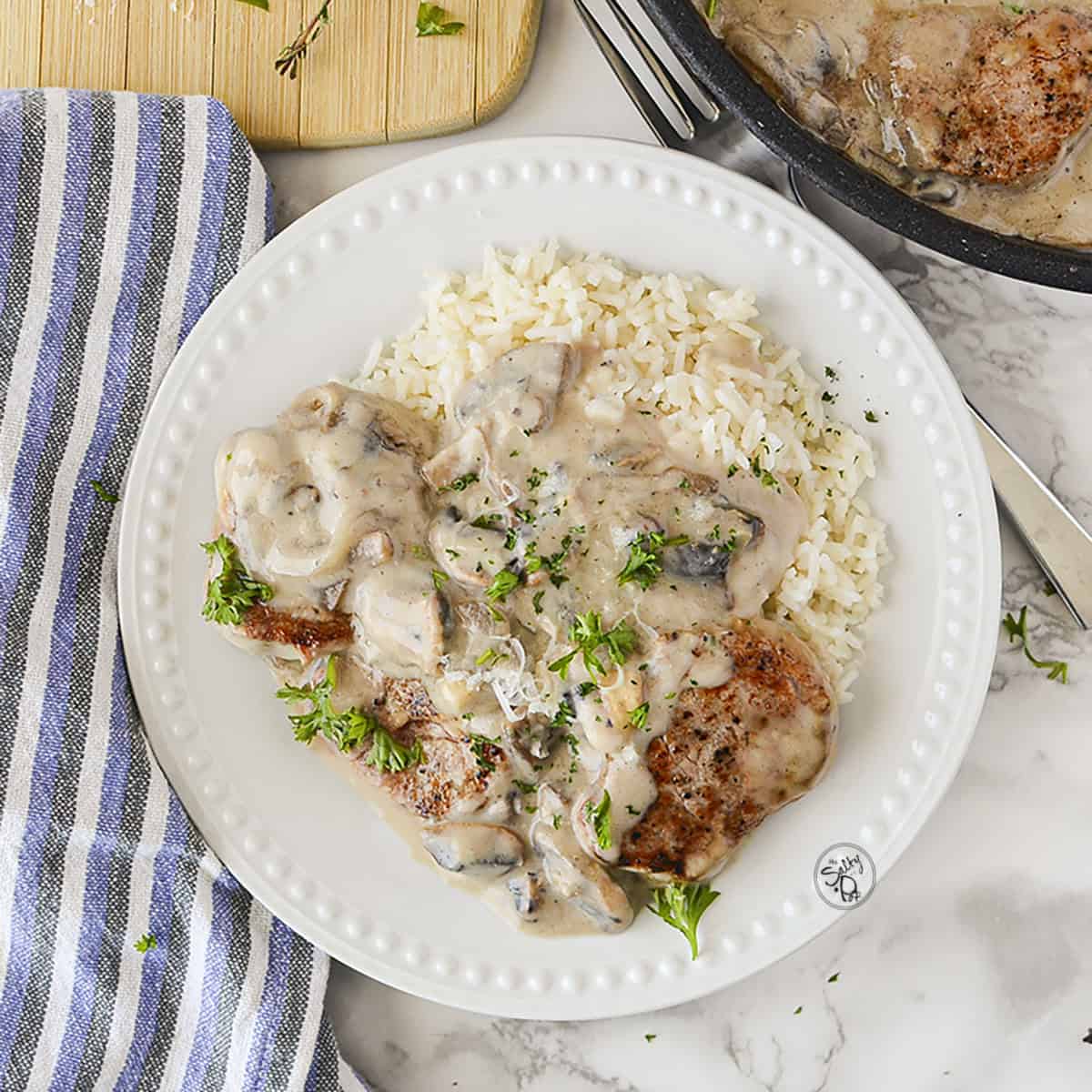 Plated pork medallions in a creamy mushroom sauce.