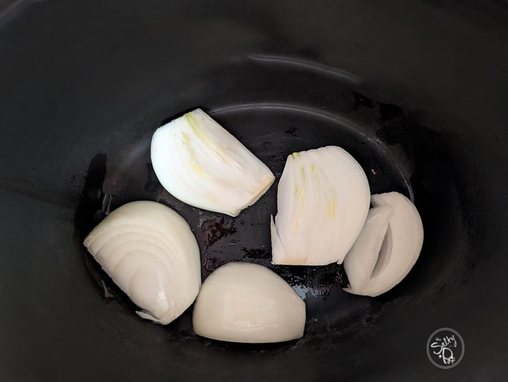 Onions at the bottom of the crock pot.