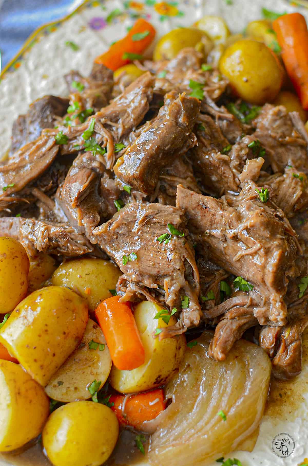 Crockpot Easy roast beef on a platter with ptoatoes, carrots and onion.