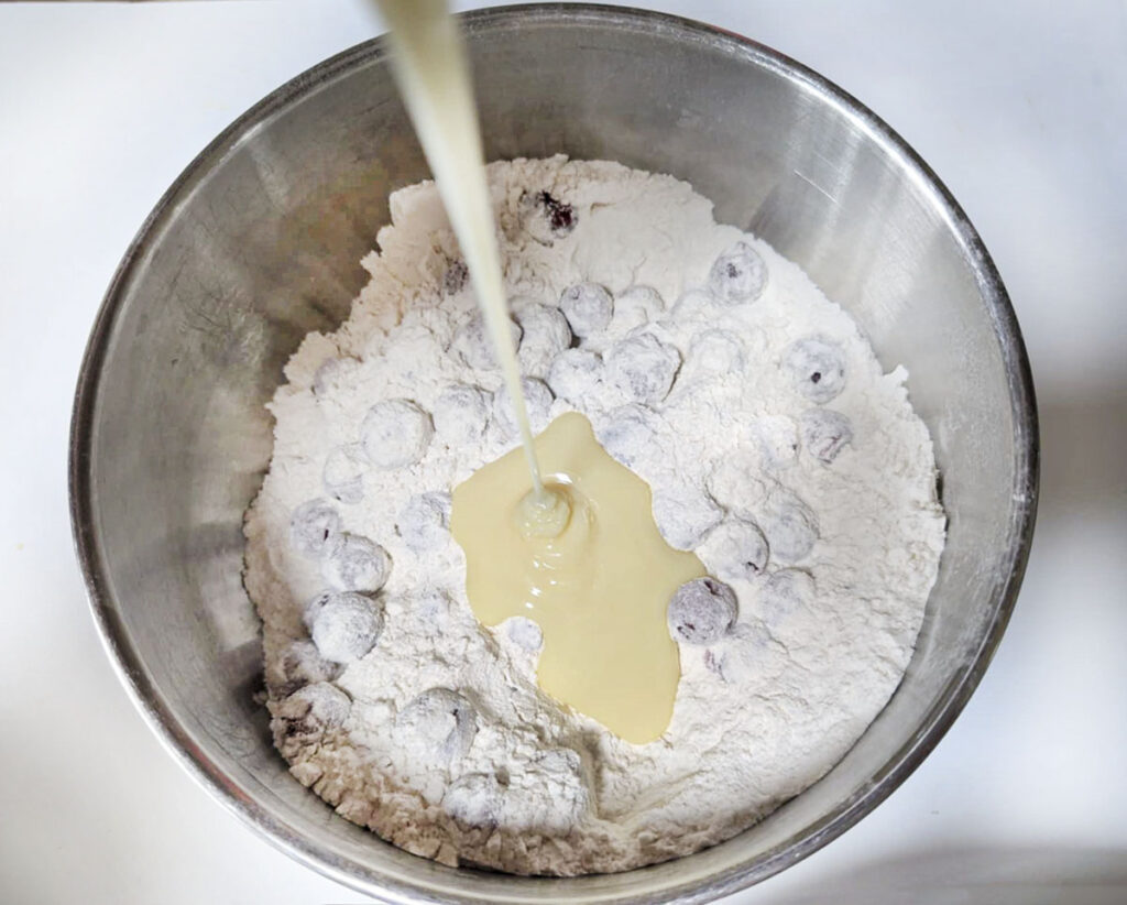 Adding the sweetened condensed milk to the dry mixture.