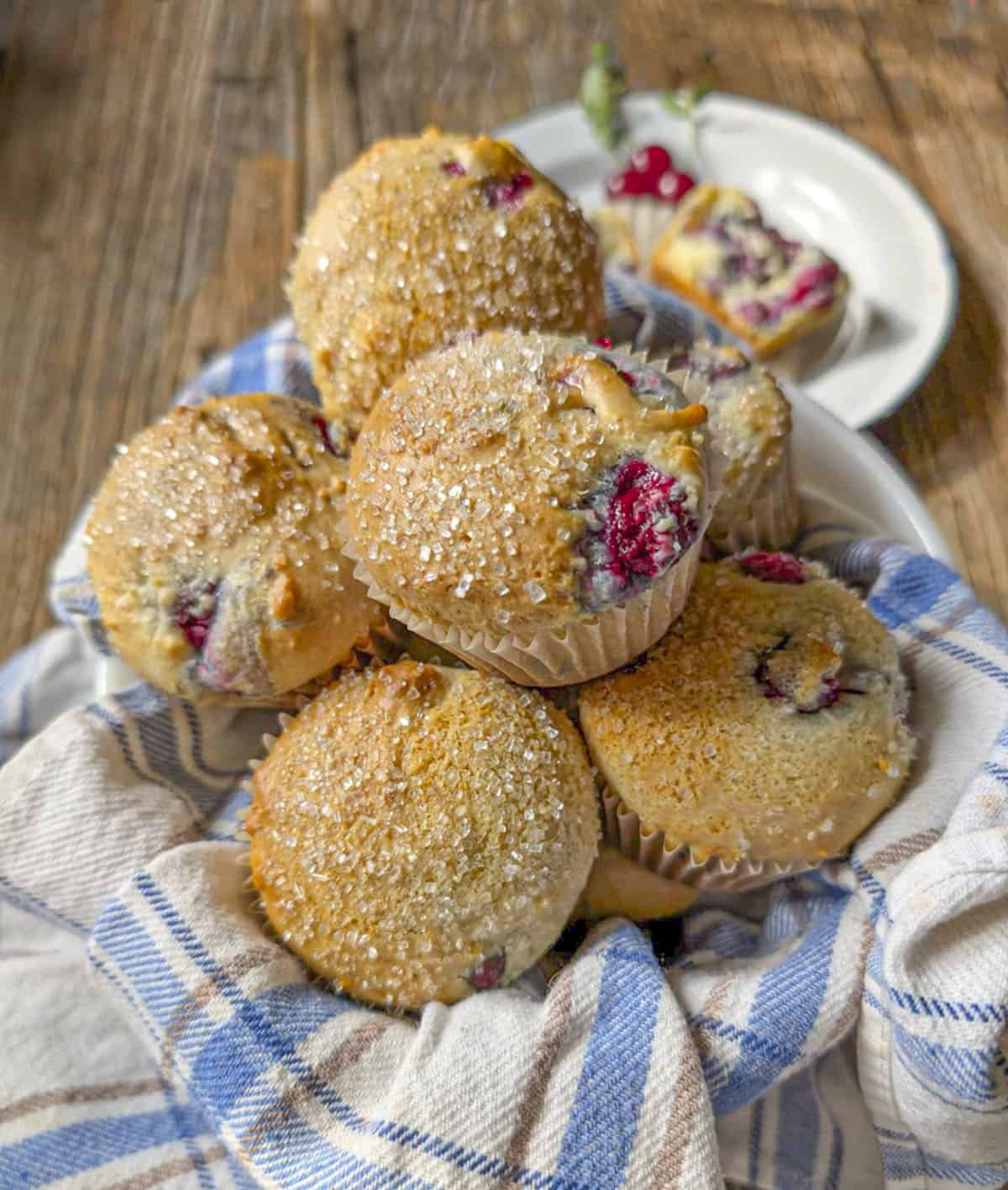 Sour cherry muffins in a basket on a wooden table.