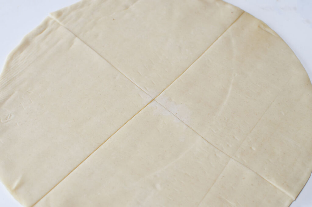A pie dough crust cut into 4 sections.