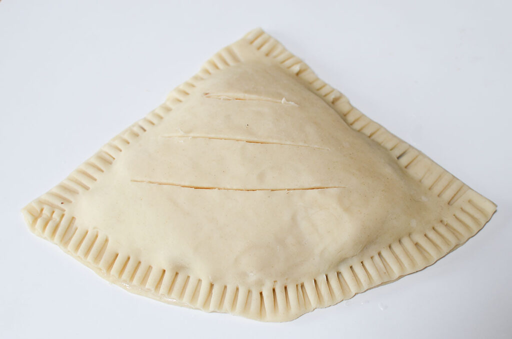 The handpie has the edges crimped and sliced for venting put in the top.