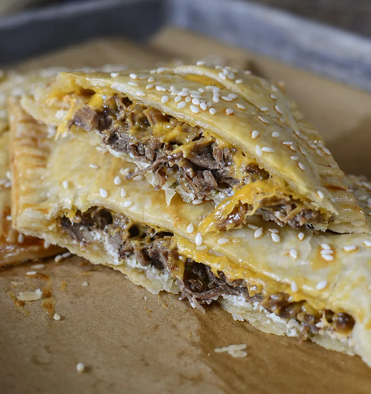 A beef and cheddar hand pie cut in half to see the filling.
