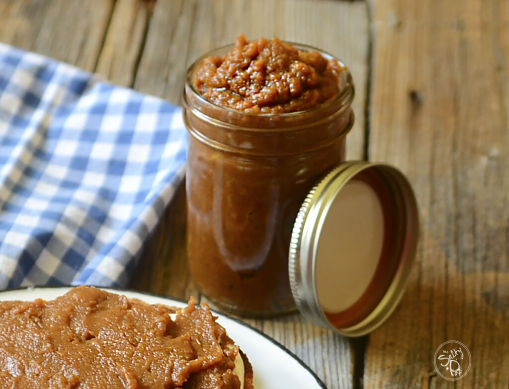 Sweet potato butter in a mason jar on a wood table.