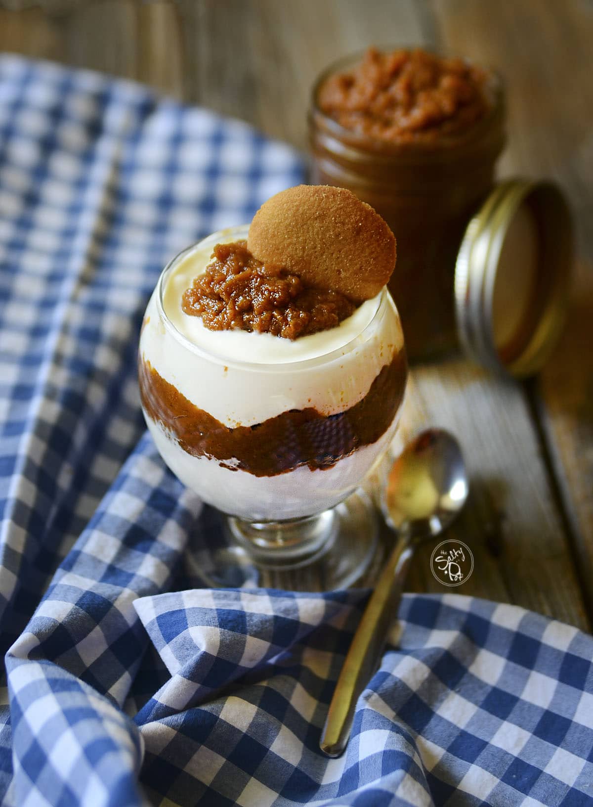 Sweet potato butter layered with yogurt in a globe dish on a checkered blue and white cloth.