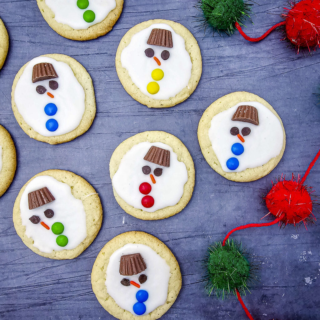 7 melted snowman cookies on a blue background.