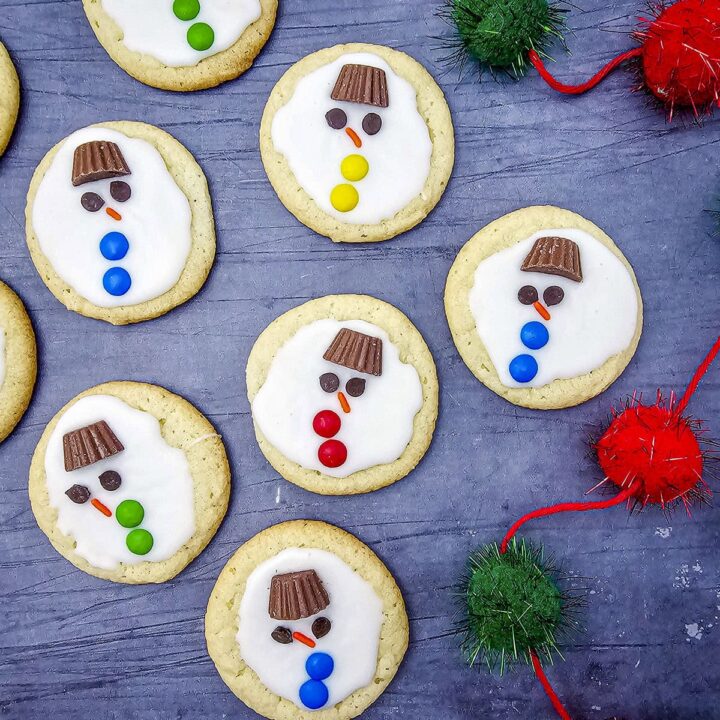 7 melted snowman cookies on a blue background.